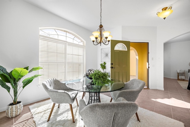 dining space featuring tile patterned floors and a notable chandelier