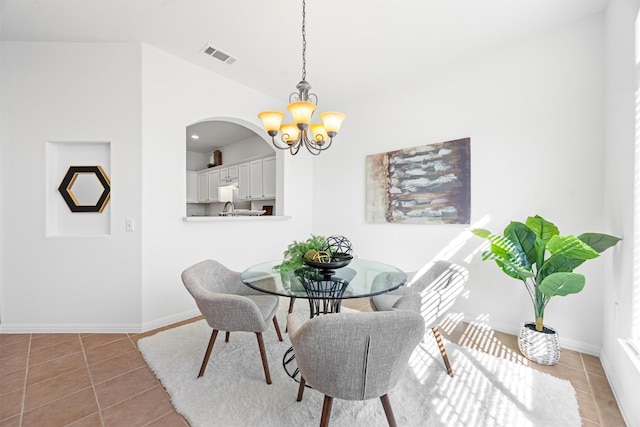 dining room with a notable chandelier and tile patterned floors