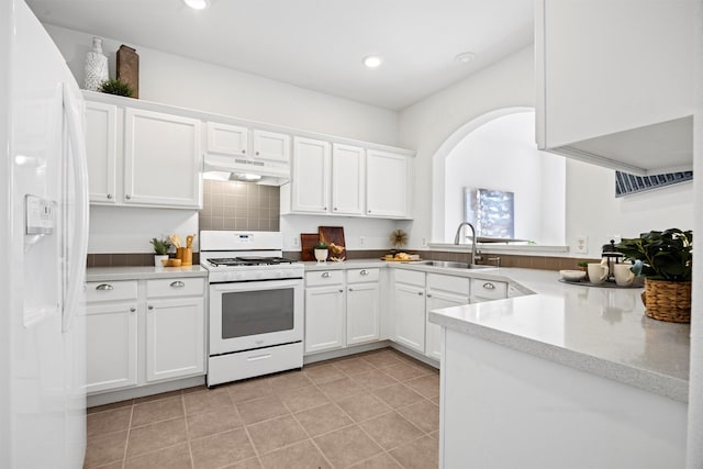 kitchen with white appliances, white cabinets, and sink