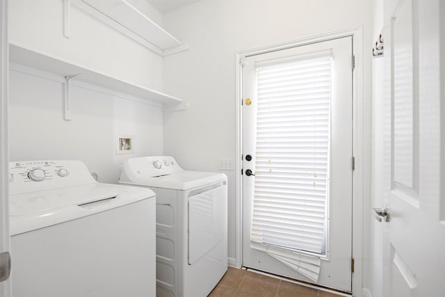 laundry room with washer and dryer and dark tile patterned floors