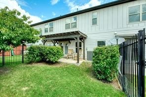 back of property with a pergola, a patio, and a lawn