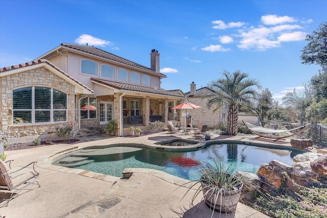 view of swimming pool featuring an in ground hot tub and a patio area