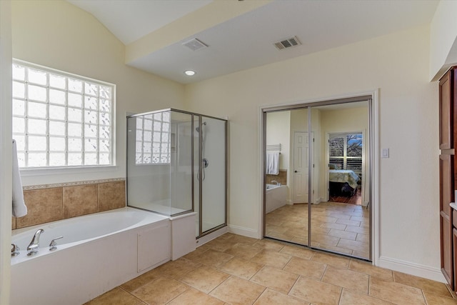 bathroom with tile patterned floors, independent shower and bath, and vaulted ceiling