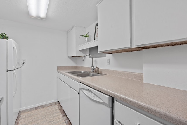 kitchen with white appliances, white cabinets, and sink