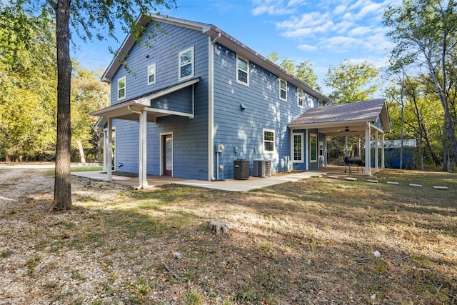 rear view of property featuring ceiling fan, central AC unit, a yard, and a patio area