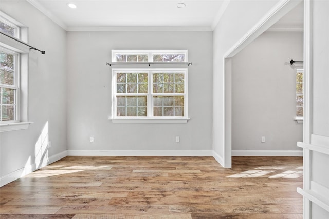 empty room featuring light wood-type flooring and crown molding