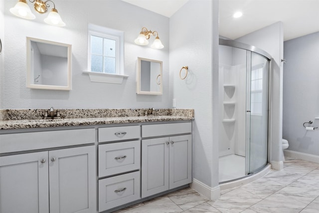 bathroom featuring an enclosed shower, vanity, and toilet