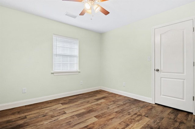 spare room with ceiling fan and dark wood-type flooring