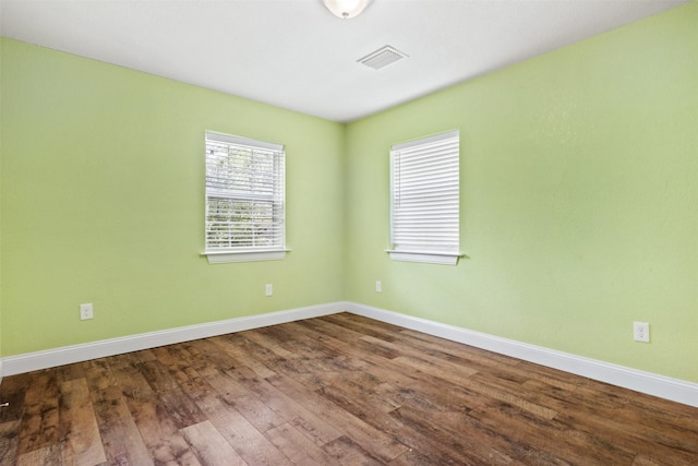 empty room with wood-type flooring and a healthy amount of sunlight