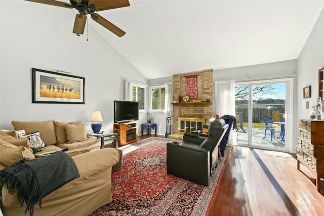 living room with ceiling fan, high vaulted ceiling, a fireplace, and wood-type flooring