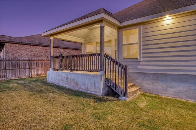 exterior entry at dusk featuring a yard