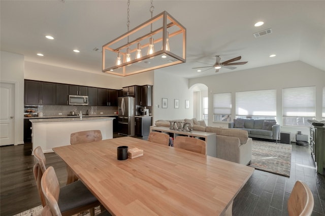 dining space featuring lofted ceiling, dark hardwood / wood-style flooring, and ceiling fan