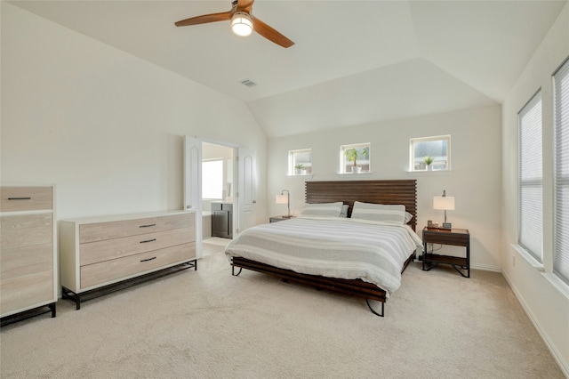 bedroom with ceiling fan, light colored carpet, ensuite bathroom, and vaulted ceiling