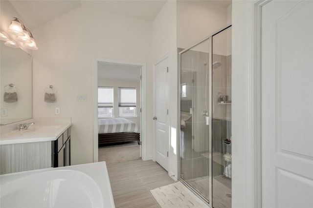 bathroom featuring vaulted ceiling, separate shower and tub, and vanity