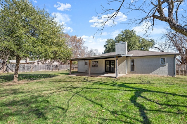 back of property with a patio area and a yard