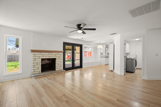 unfurnished living room featuring ceiling fan, french doors, plenty of natural light, and light hardwood / wood-style flooring