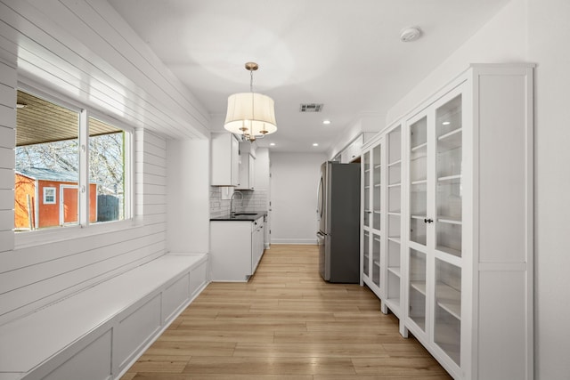 corridor featuring light wood-type flooring and sink