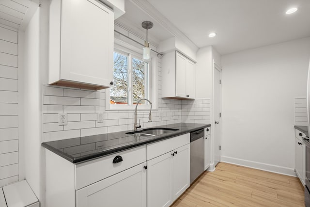 kitchen featuring decorative light fixtures, stainless steel dishwasher, sink, light wood-type flooring, and white cabinets