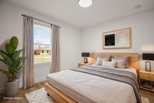 bedroom with multiple windows and light hardwood / wood-style floors