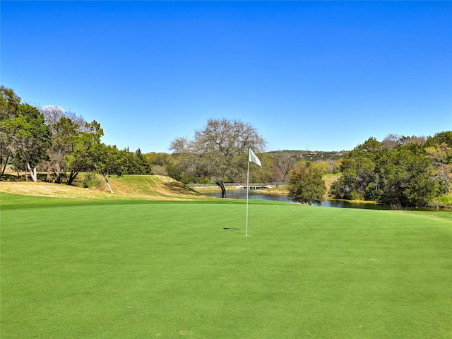 view of home's community with a water view and a lawn