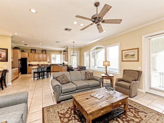 living room with ceiling fan, light tile patterned flooring, crown molding, and a healthy amount of sunlight