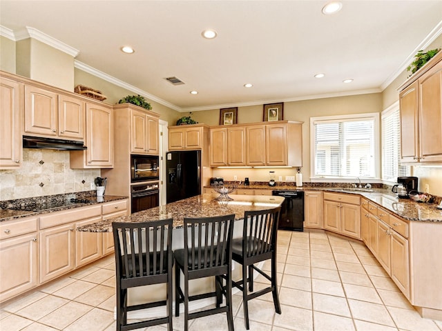 kitchen featuring black appliances, light tile patterned floors, dark stone counters, a kitchen island, and light brown cabinets