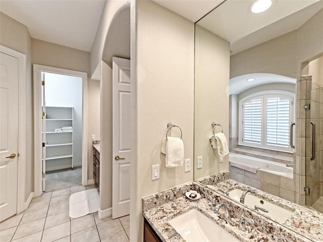 bathroom featuring tile patterned flooring, separate shower and tub, and vanity