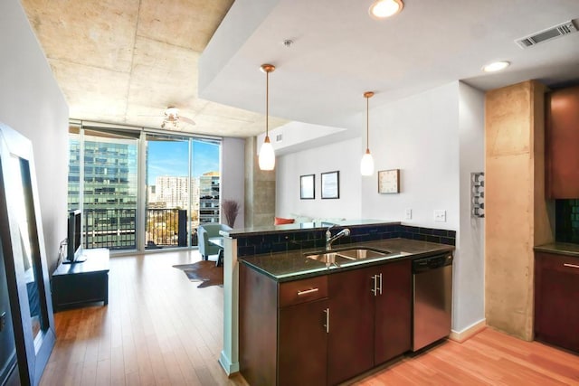 360 Nueces St Unit 1318, Austin, TX 78701 - kitchen with dishwasher, dark countertops, floor to ceiling windows, light wood-style floors, and a peninsula