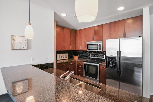 kitchen with sink, hanging light fixtures, stainless steel appliances, decorative backsplash, and dark stone counters