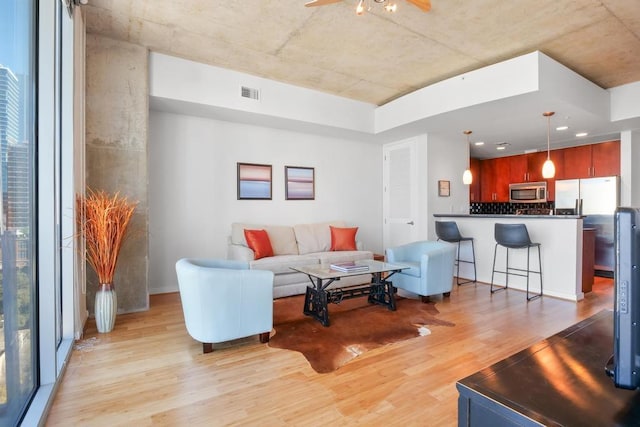 living room featuring ceiling fan and light hardwood / wood-style floors