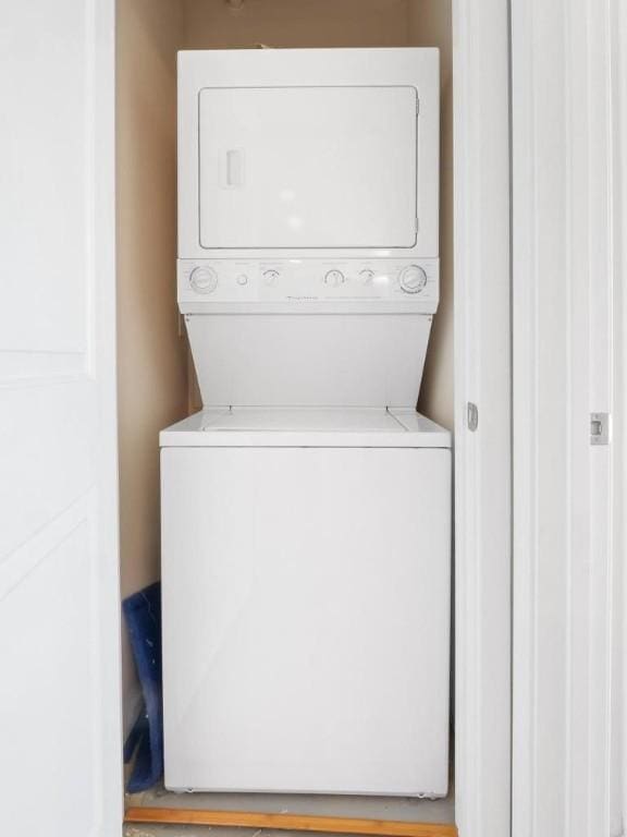 clothes washing area with stacked washer and dryer