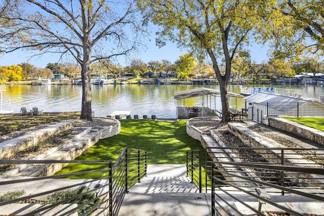 view of home's community with a water view and a yard