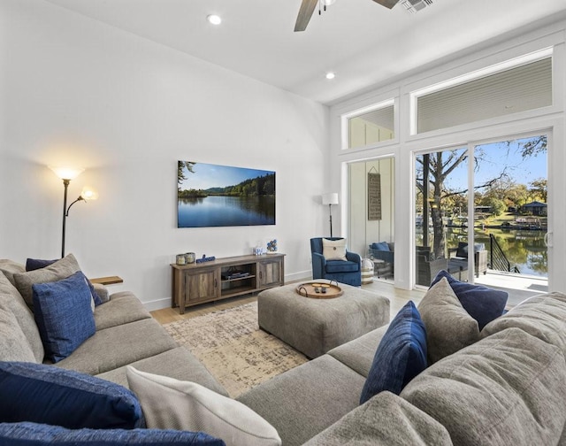 living room with ceiling fan and light hardwood / wood-style floors