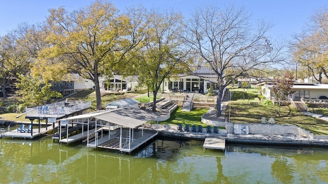 view of dock with a yard and a water view