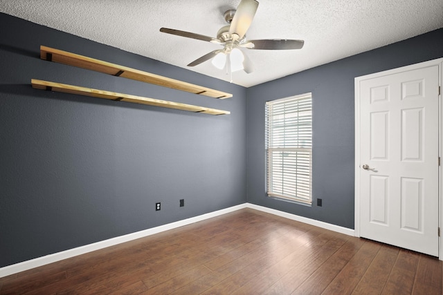 unfurnished bedroom with a textured ceiling, ceiling fan, and dark hardwood / wood-style floors