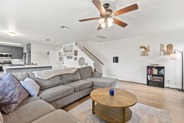 living room featuring ceiling fan and light hardwood / wood-style floors