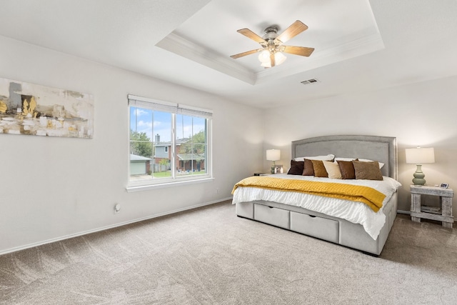 carpeted bedroom with crown molding, ceiling fan, and a tray ceiling