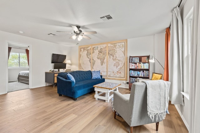 living room with ceiling fan and light hardwood / wood-style flooring