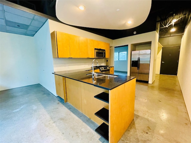 kitchen with sink, stainless steel appliances, and dark stone counters