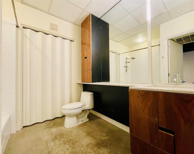 full bathroom featuring a paneled ceiling, vanity, toilet, and concrete flooring