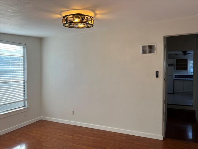 spare room with plenty of natural light and wood-type flooring