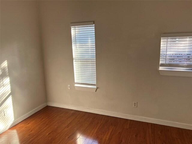 unfurnished room with hardwood / wood-style flooring