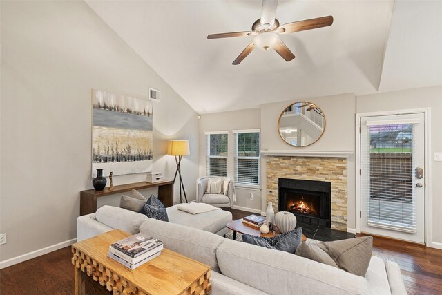 living room featuring a fireplace, ceiling fan, dark hardwood / wood-style flooring, and plenty of natural light