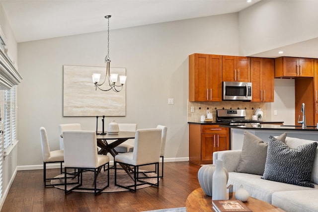 kitchen featuring stainless steel appliances, decorative backsplash, a notable chandelier, hanging light fixtures, and sink