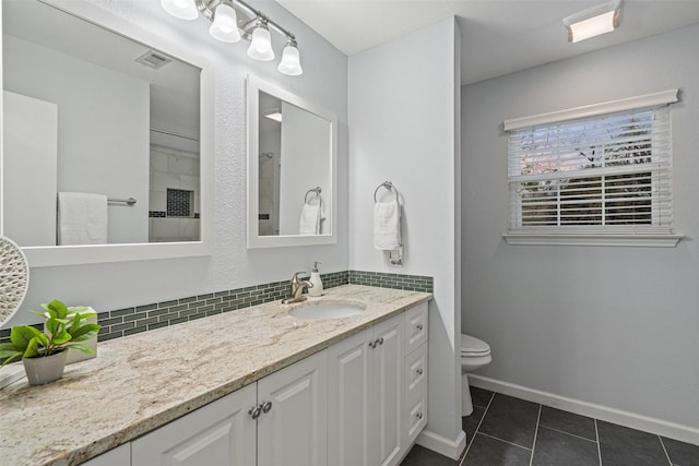 bathroom with toilet, vanity, tile patterned floors, and tasteful backsplash