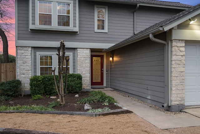 exterior entry at dusk featuring a garage