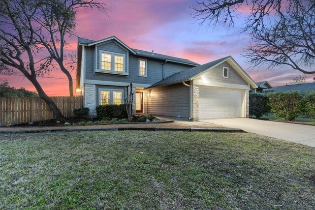 view of property featuring a garage and a yard