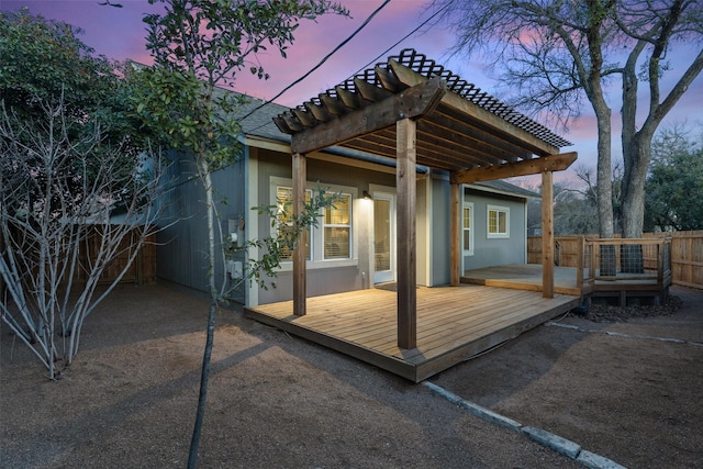 patio terrace at dusk with a pergola and a deck