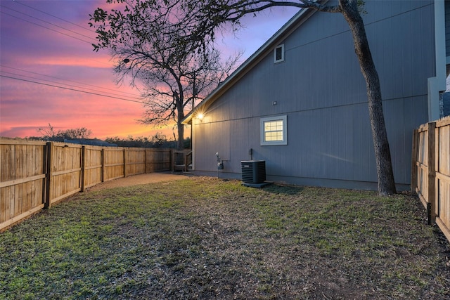 yard at dusk featuring central air condition unit