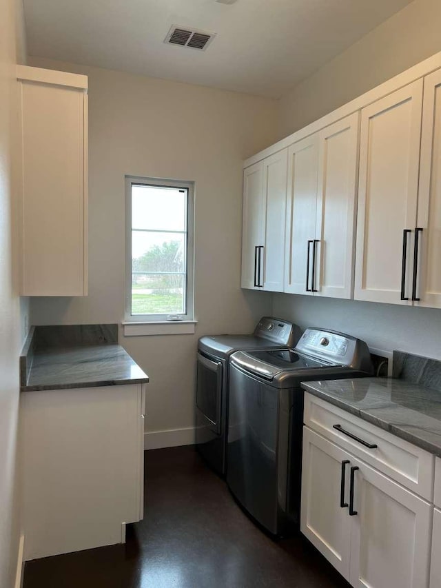 laundry room with cabinets and washing machine and clothes dryer